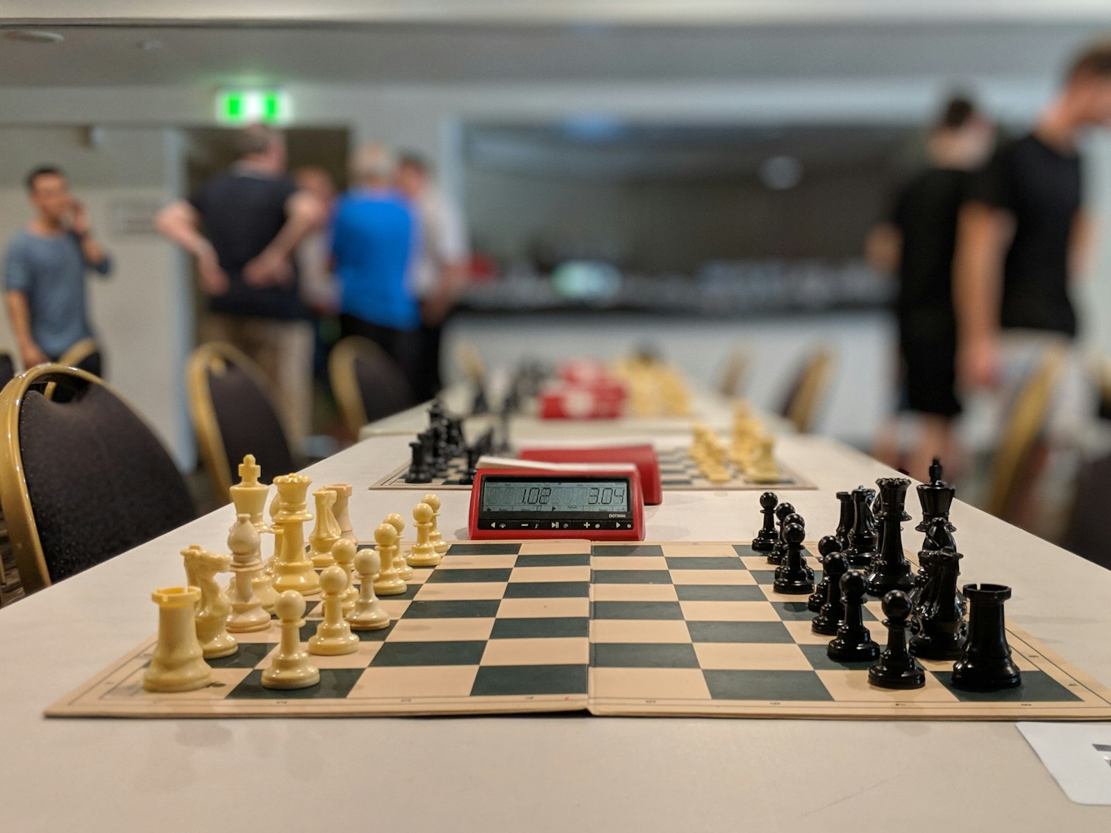 A tournament hall set with chess boards and clocks before play begins