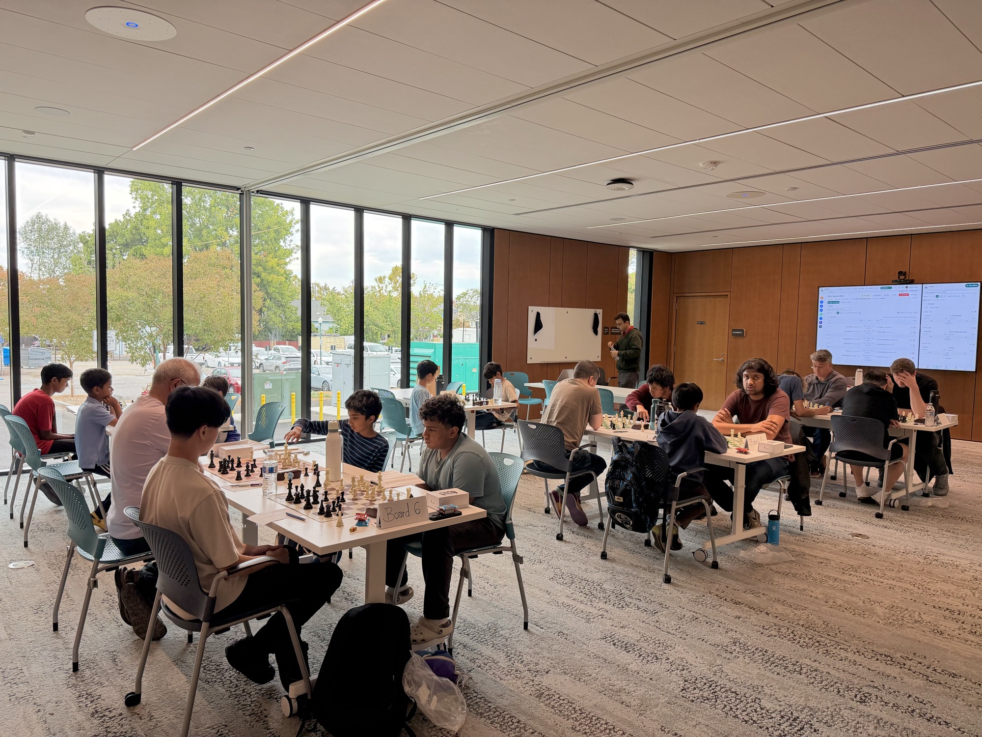 Wide view of players competing across the room at the C4 x SMC tournament.