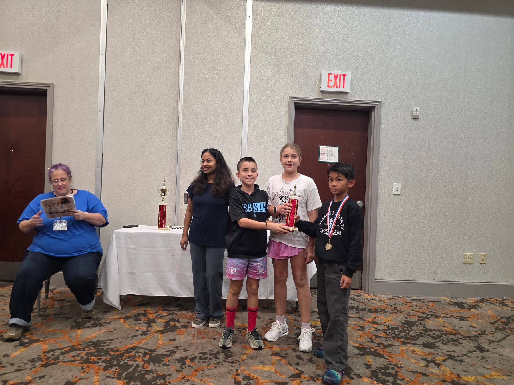 Children receiving a trophy at a Mohar Chess Academy event.