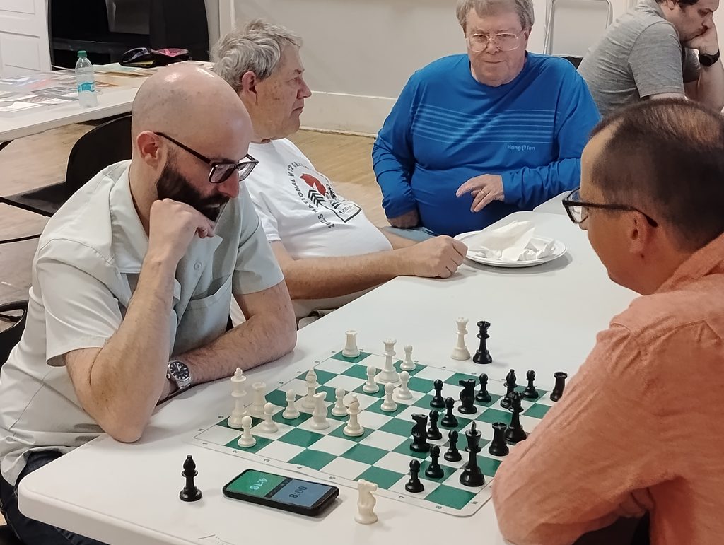 Spokane Chess Club members gathered around a chessboard.