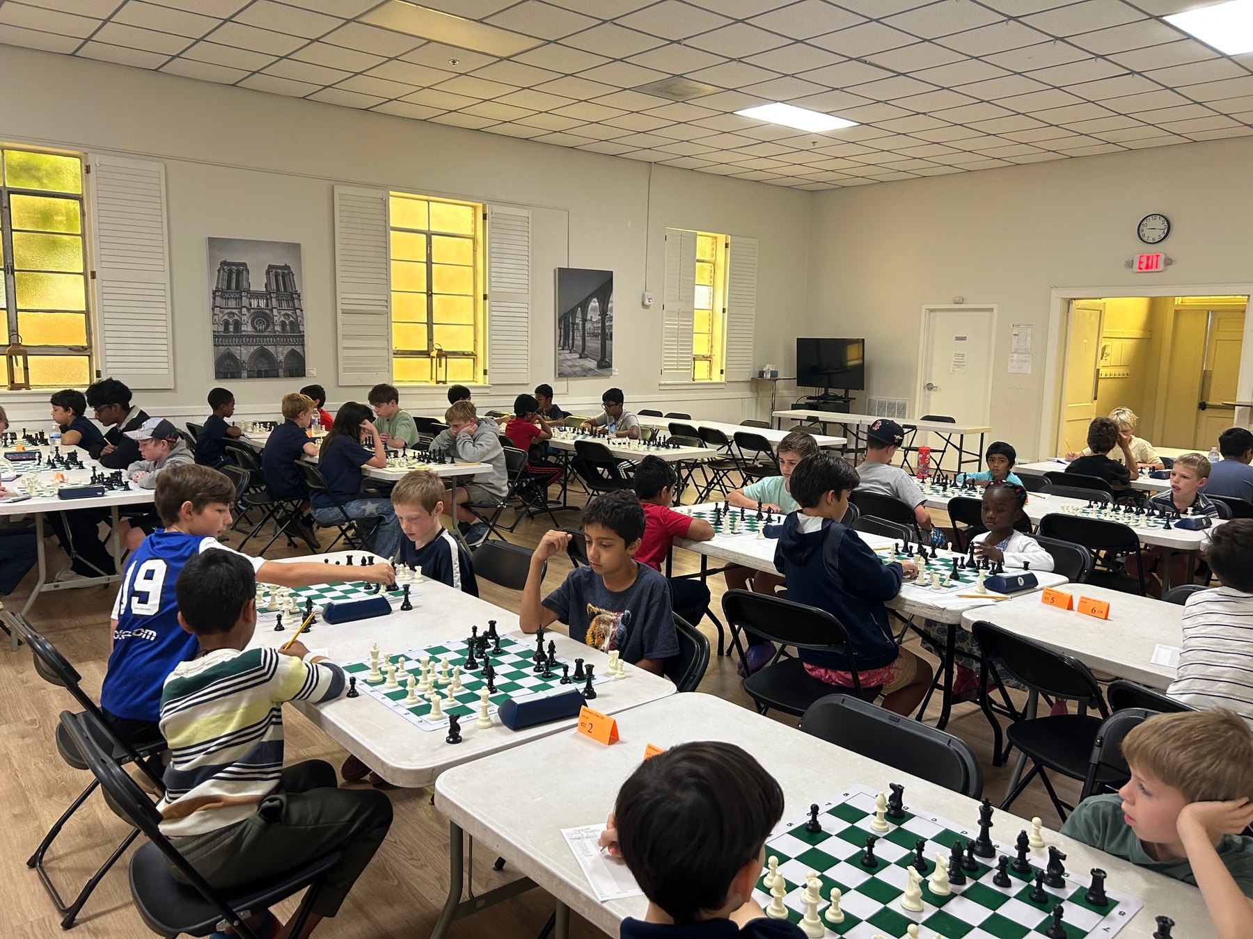 Stonehaven scholastic players seated at chessboards throughout the tournament room.